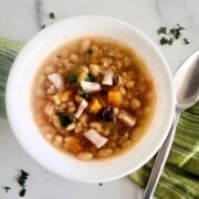 Bowl of homemade slow cooker navy bean and leftover ham soup.