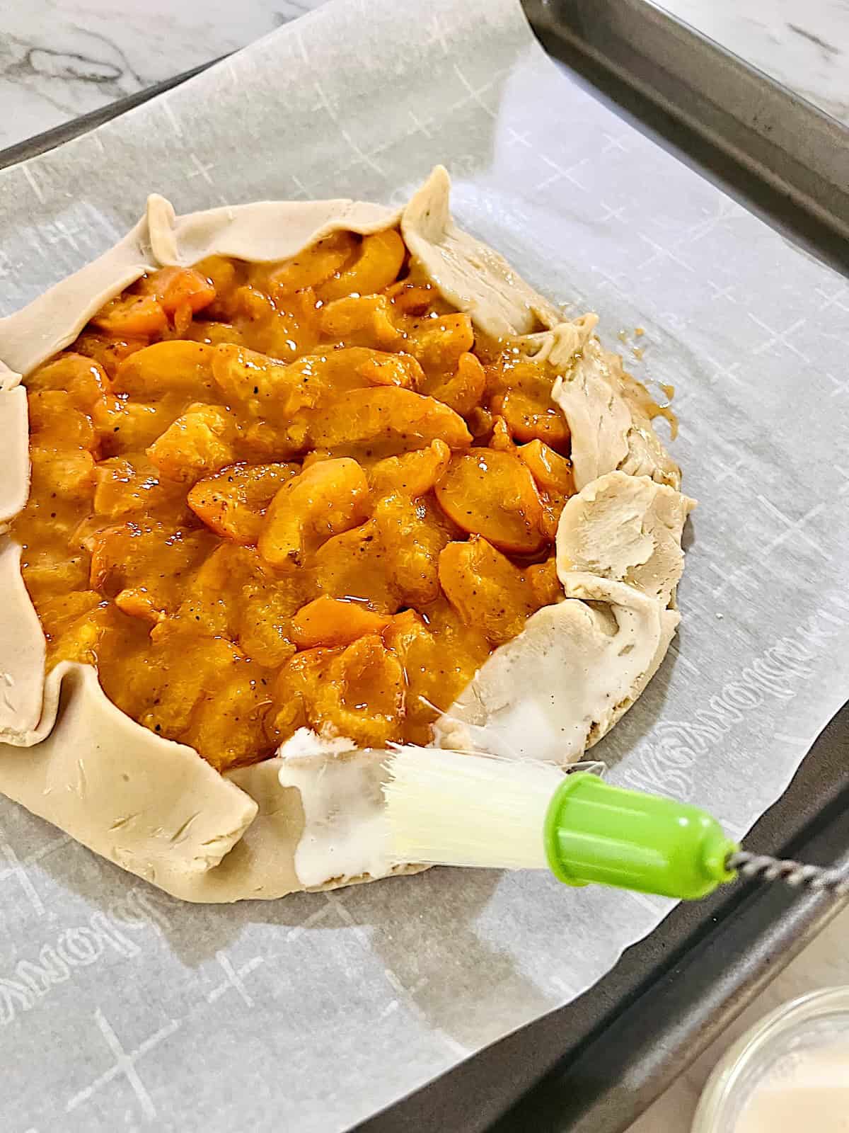  Brushing cream on the crust edges.