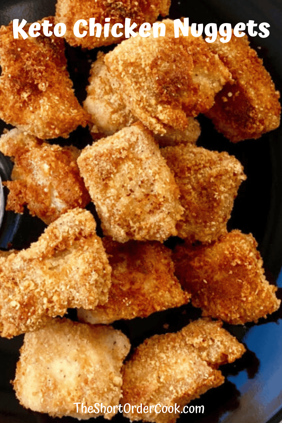 Plate of low carb keto chicken nuggets with almond flour parmesan coating and deep fried until golden.