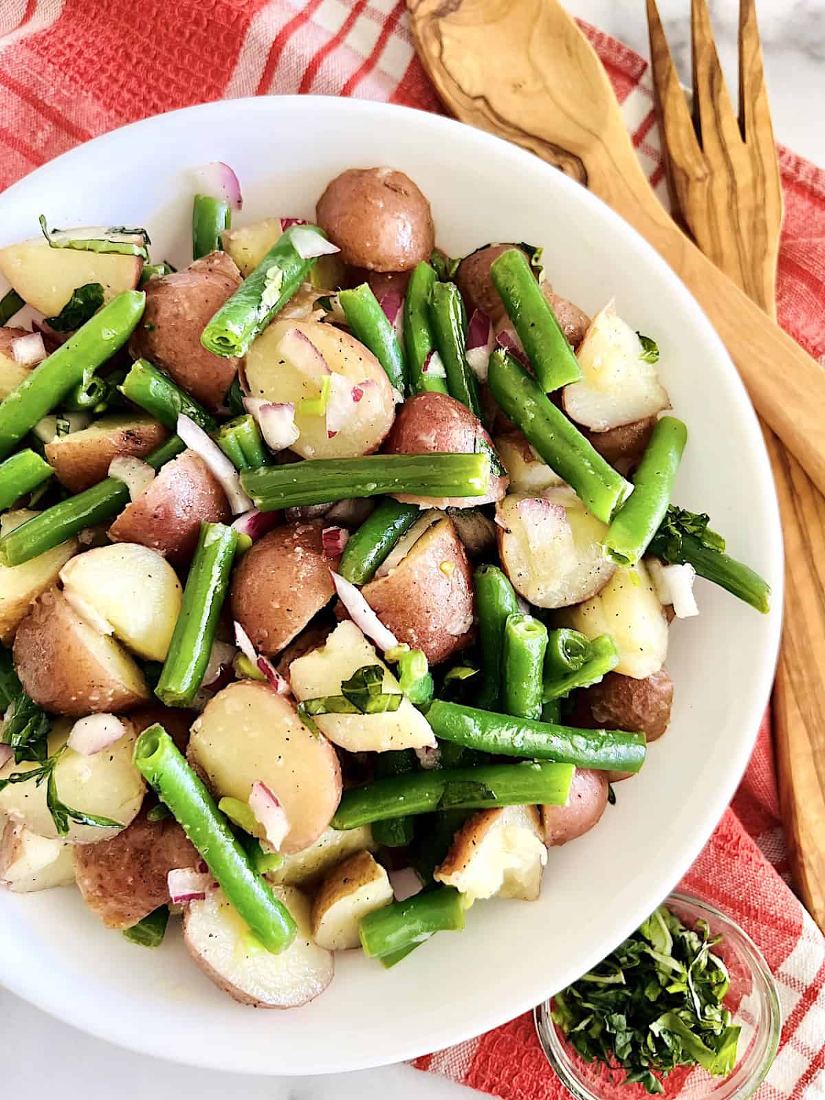Italian Green Bean and Potato Salad Best Recipe in a serving bowl topped with fresh herbs.