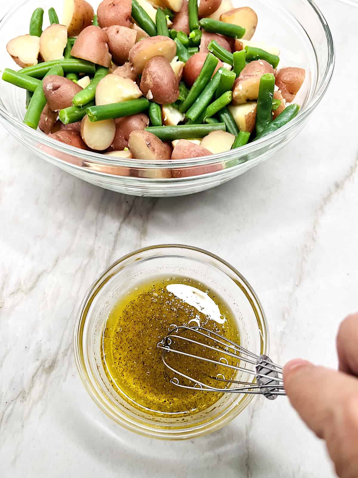 Whisking dressing in a small bowl.