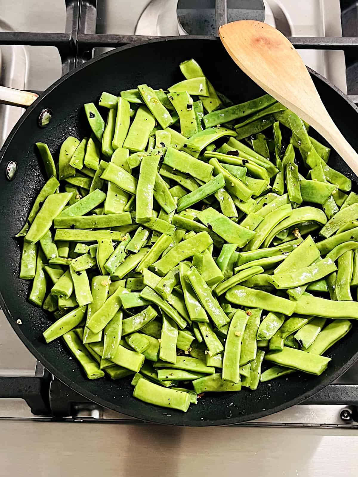 Garlic Sauteed Romano Beans in skillet cooking.