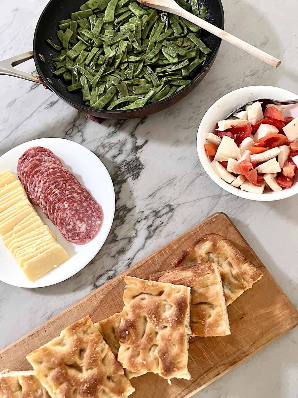Garlic Sauteed Romano Beans ready to eat wtih focaccia tomato salad and Italian cold cuts