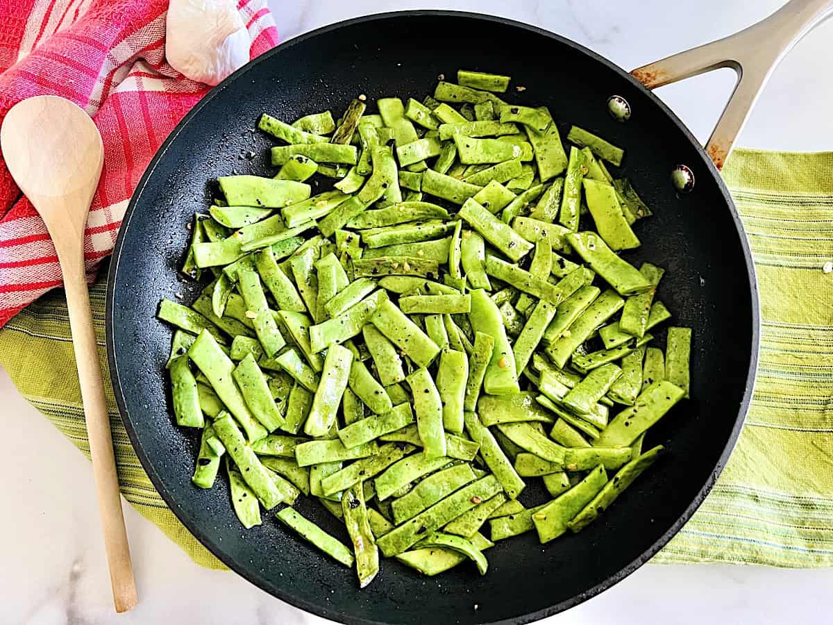 Italian board beans in a skillet with garlic and spices ready to serve the romano green beans as a side dish.
