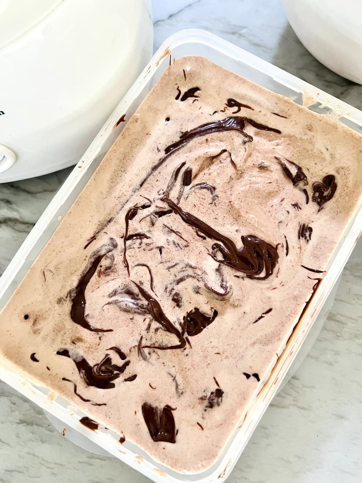 Nutella Ice Cream In container layered with swirls of Nutella ready to freeze.