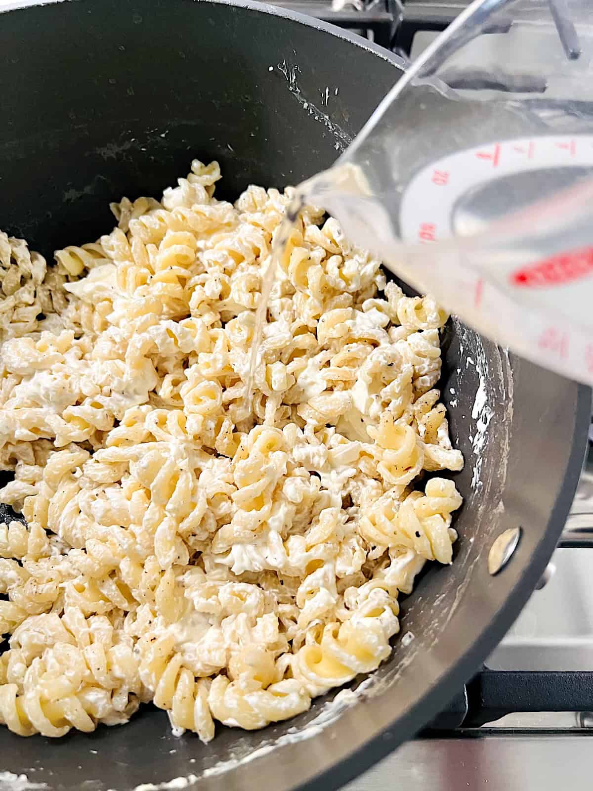 Philadelphia Cream Cheese Pasta Sauce Adding pasta water to the pot.
