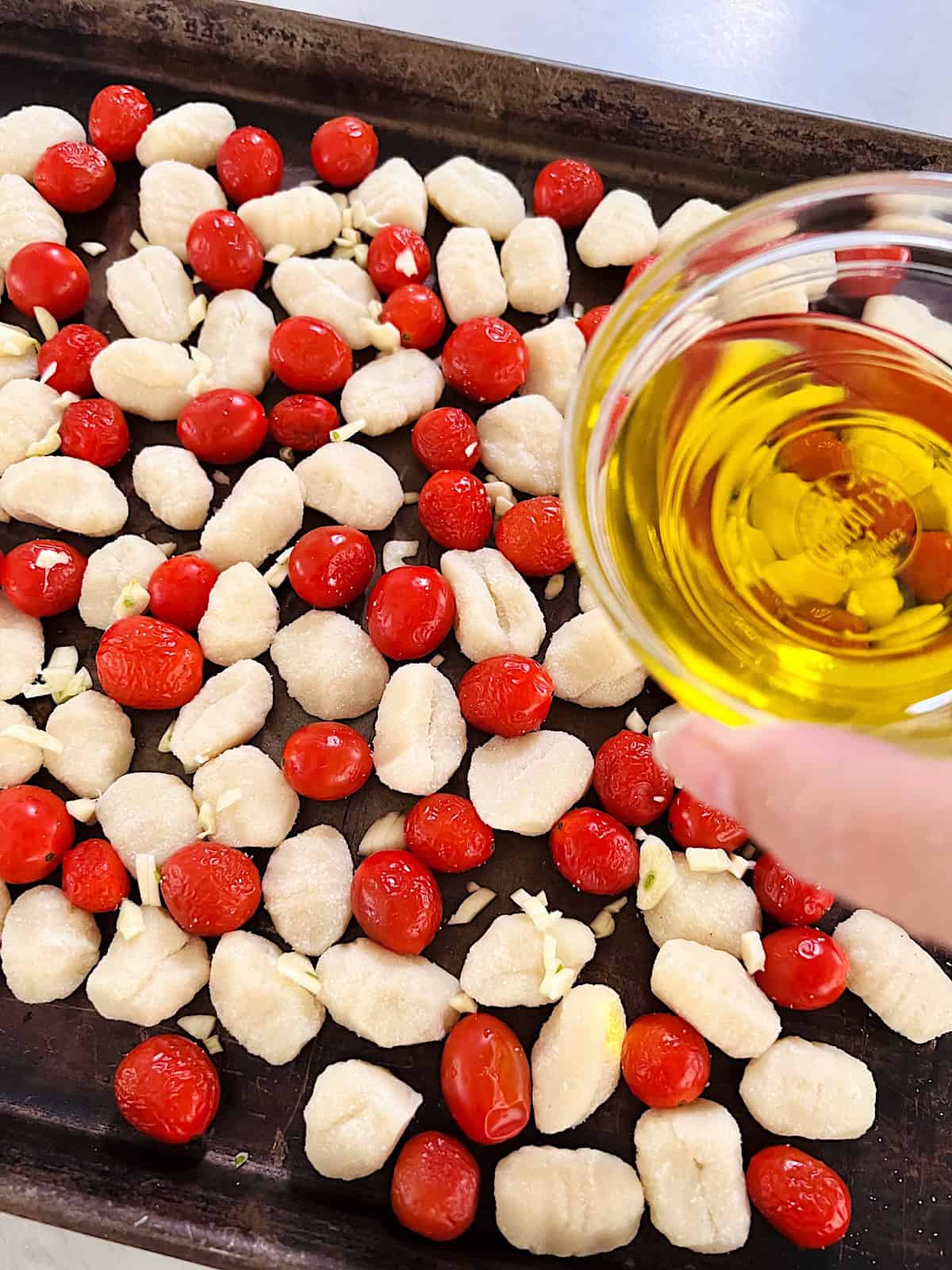 Sheet Pan Tomato Basil Gnocchi Adding the olive oil.