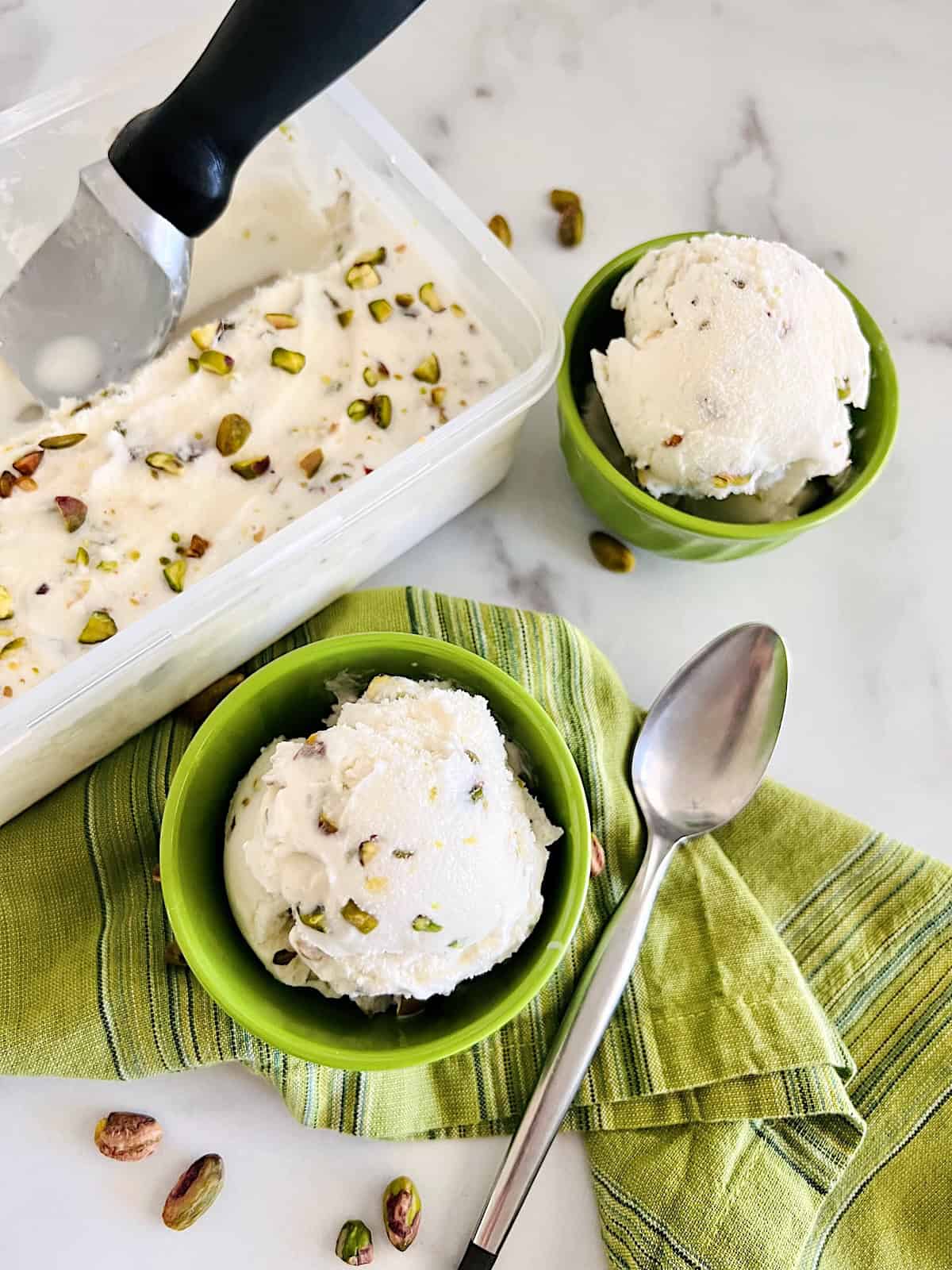 Pistachio Ice Cream Overhead scooping from container into individual bowls ready to eat.