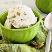 Pistachio Ice Cream scooped in a bowl loaded with nuts.