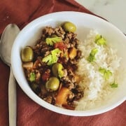 Slow Cooker Cuban Picadillo made with ground beef in a bowl with rice.