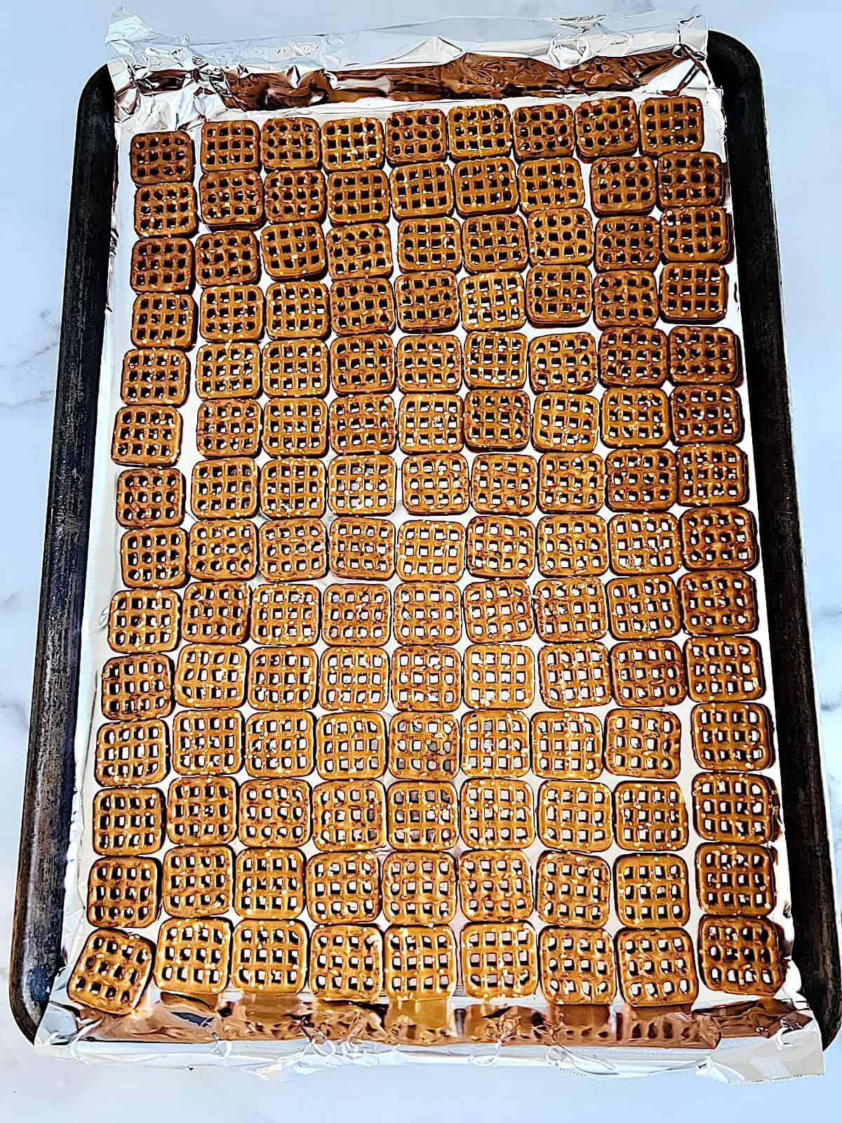 Square snaps lined up on foil lined baking sheet.