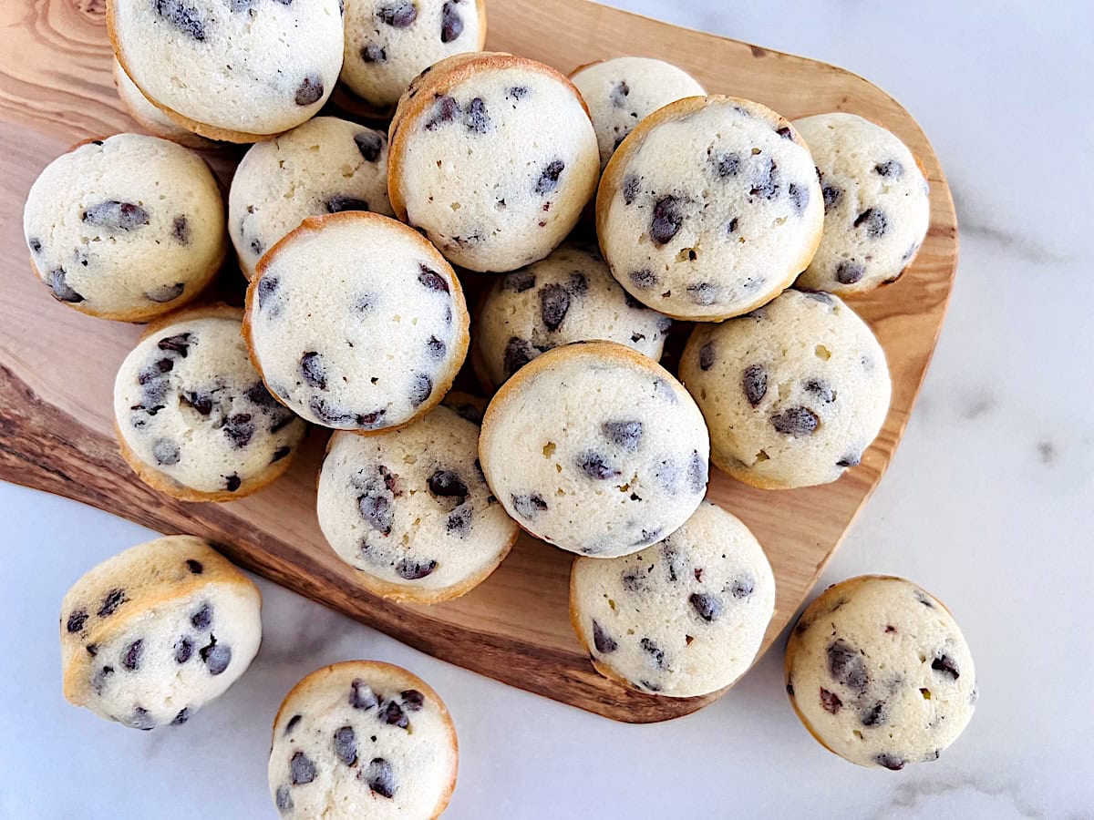 Mini muffins with semi-sweet chocolate chips on a board to serve.
