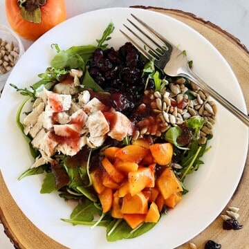 Winter Green Salad with Turkey, winter persimmons, cranberry, sunflower seeds, & oil & vinegar dressing.