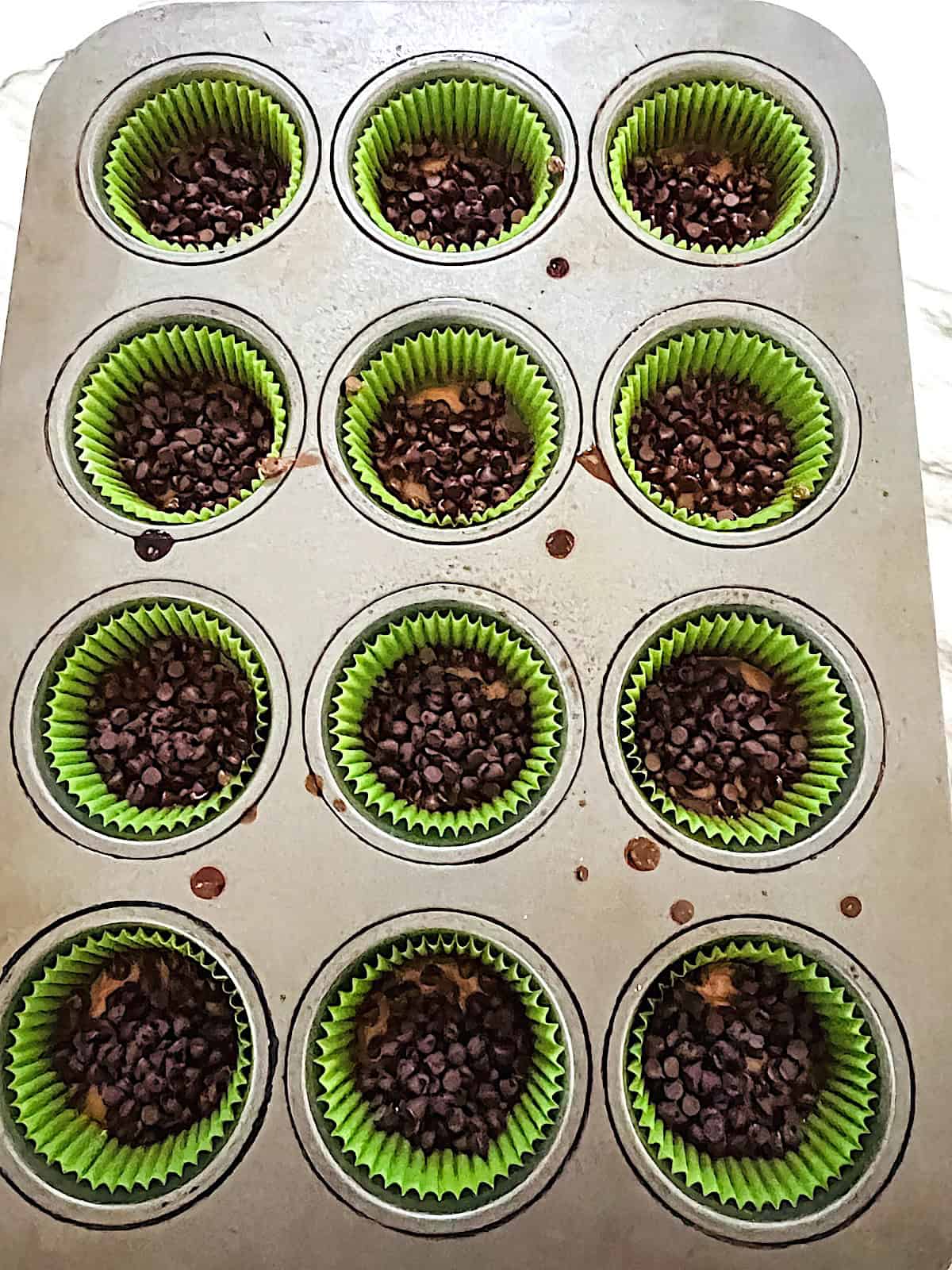 Ritz Cracker Toffee Cookies Muffin Pan with crack cookies right out of the oven topped with mini morsels.