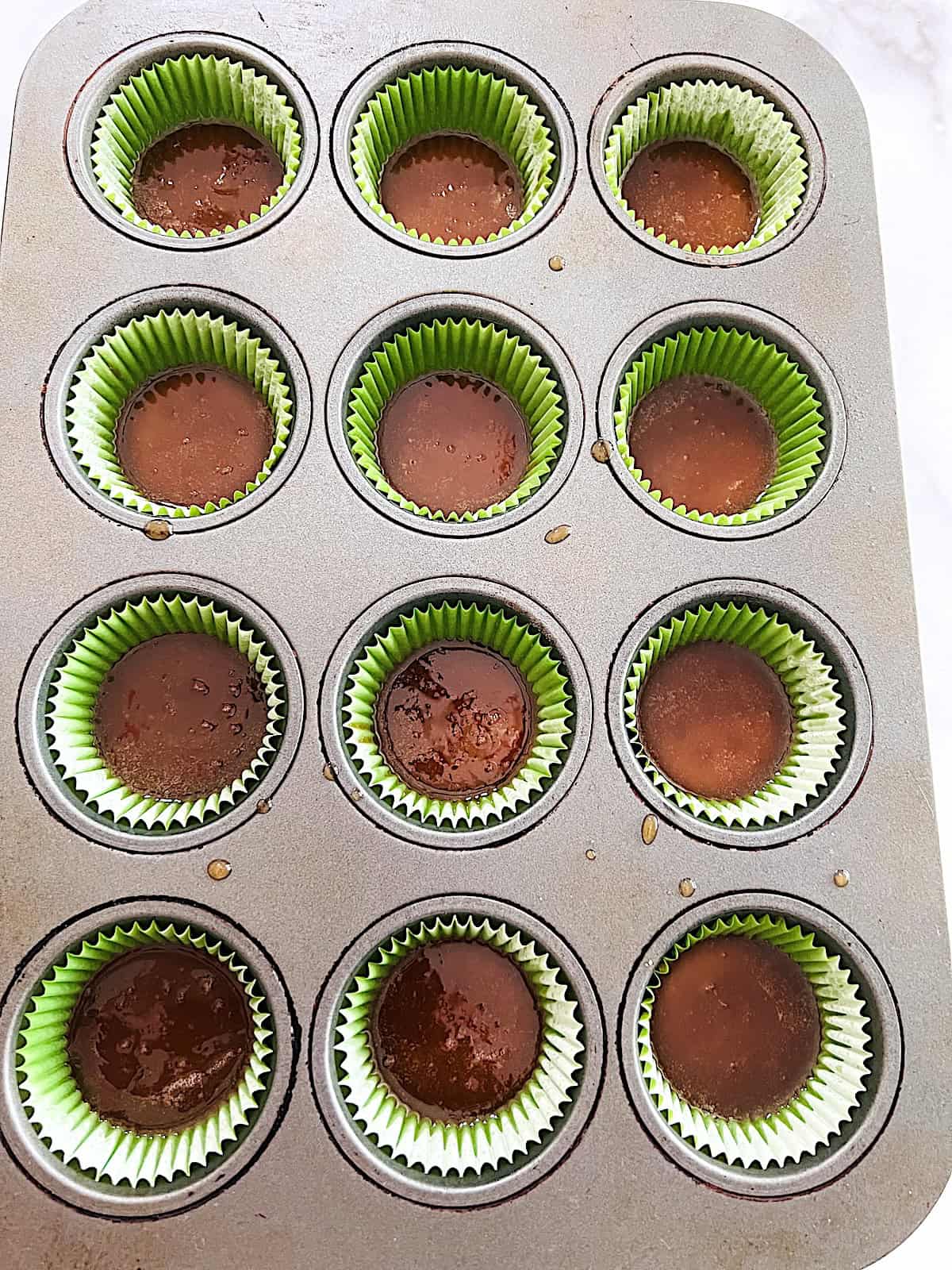 Ritz Cracker Toffee Cookies Muffin pan with Ritz topped with brown sugar toffee before baking.