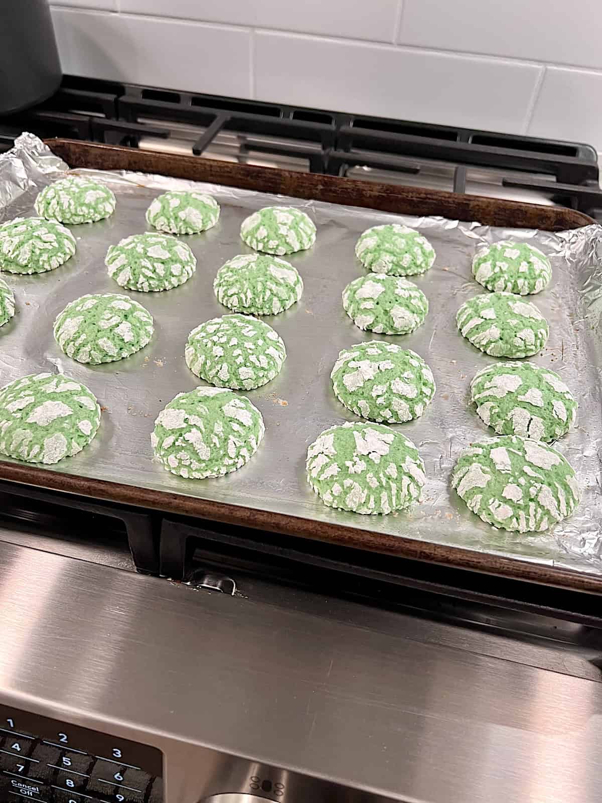 Green Cake Mix Crinkle Cookies Baked resting on the cookie sheet