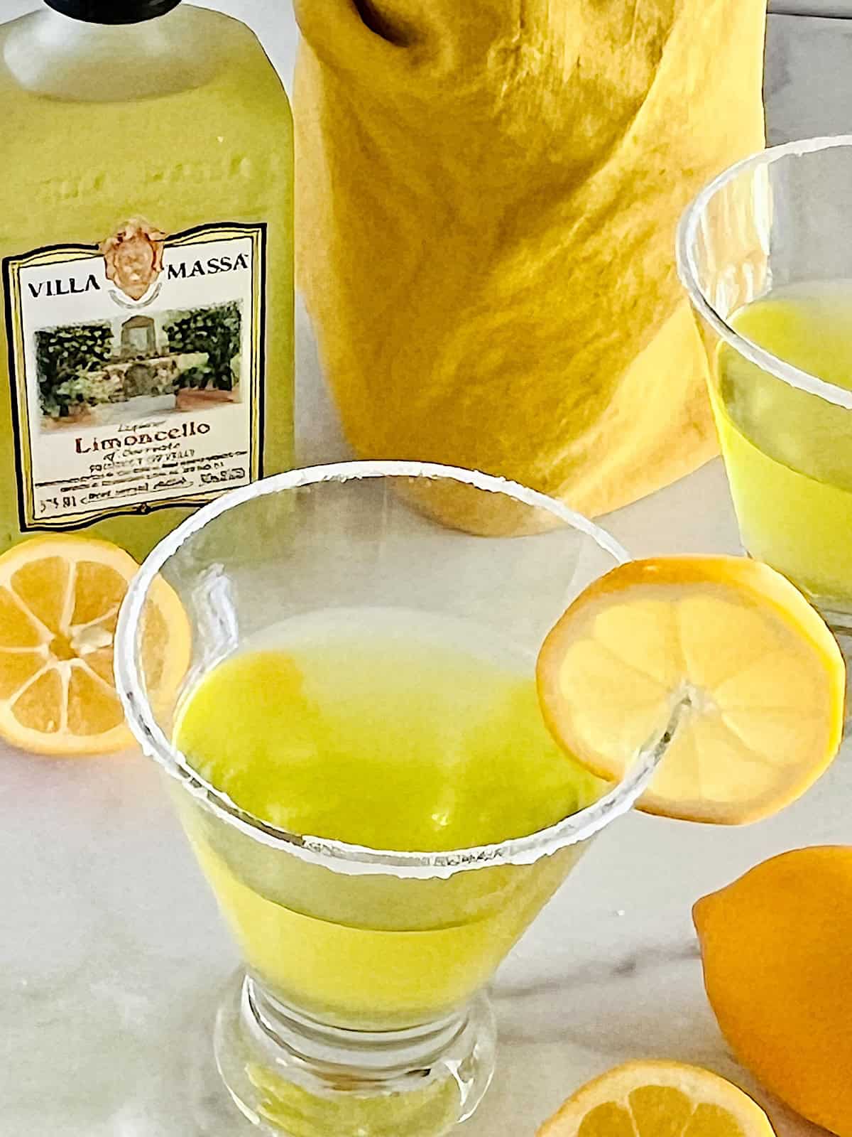 Lemon Drop Martini with Limoncello Best recipe ready to sip in sugar rimmed martini glasses with fresh lemon slices.