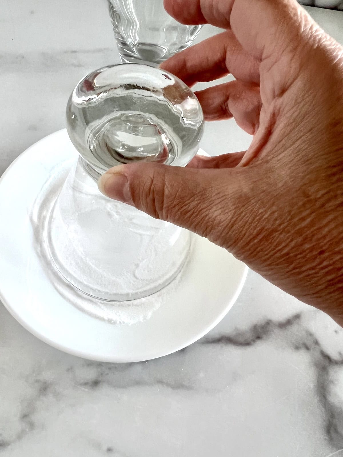Dipping glass rim in sugar.