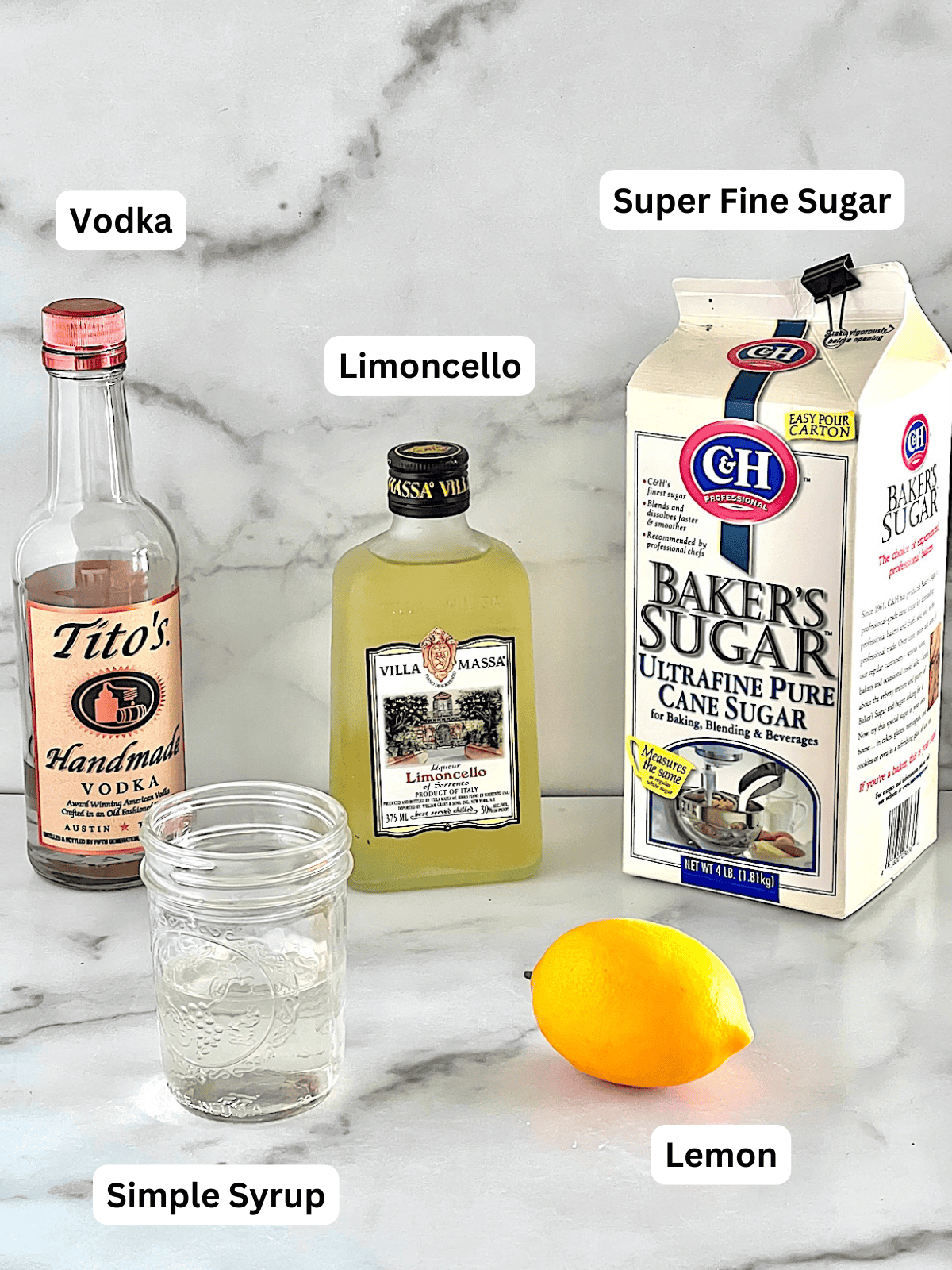 Ingredients for making lemon drop martinis with limoncello and vodka.