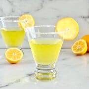 Lemon Drop cocktail with Limoncello in two martini glasses with a slice of lemon and sugar rim.