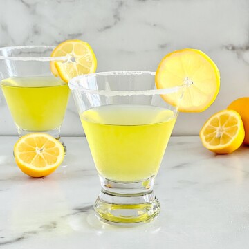 Lemon Drop cocktail with Limoncello in two martini glasses with a slice of lemon and sugar rim.