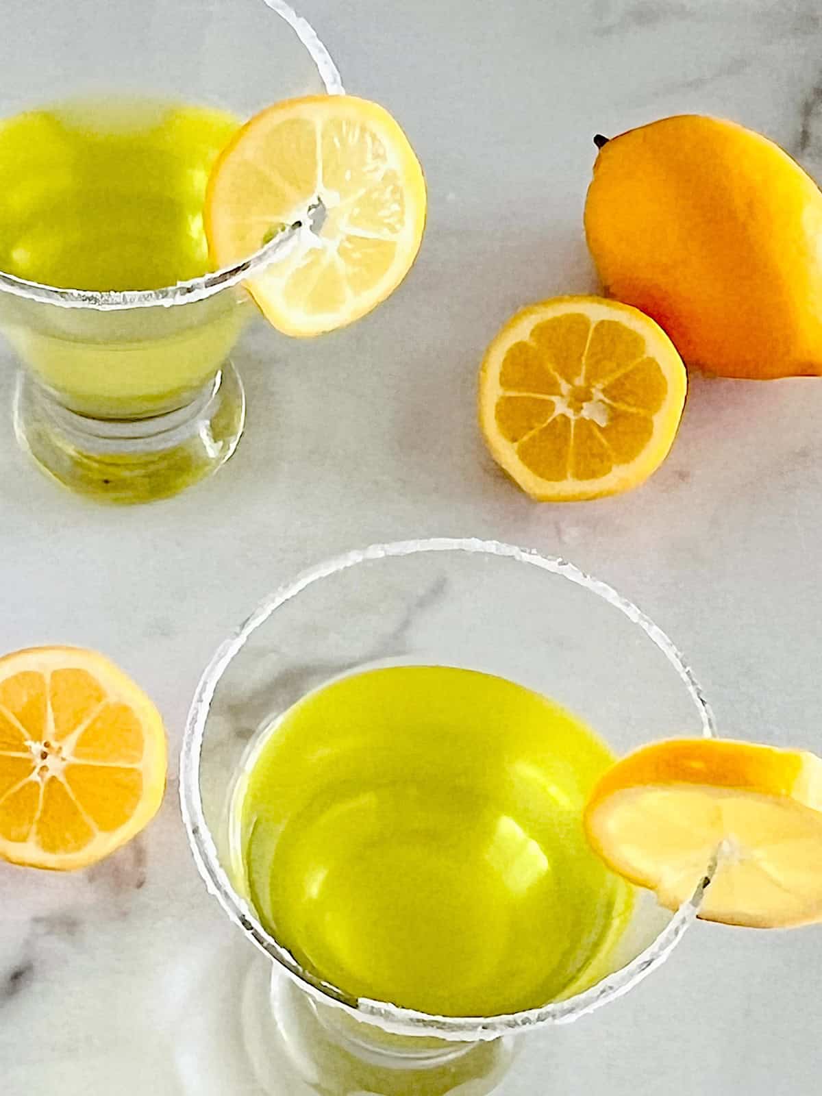 Lemon Drop Martini with Limoncello ready to drink in glasses with lemon slice garnish on sugared rims.