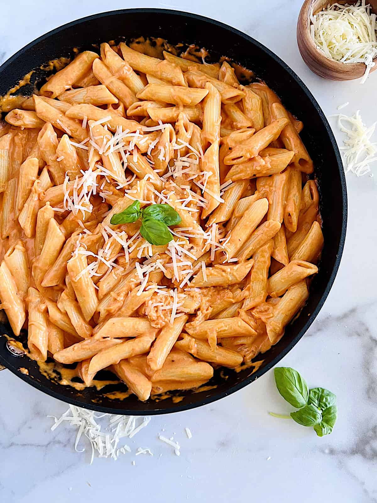 Penne alla Vodka Overhead in skillet ready to serve with shredded parmesan on top.
