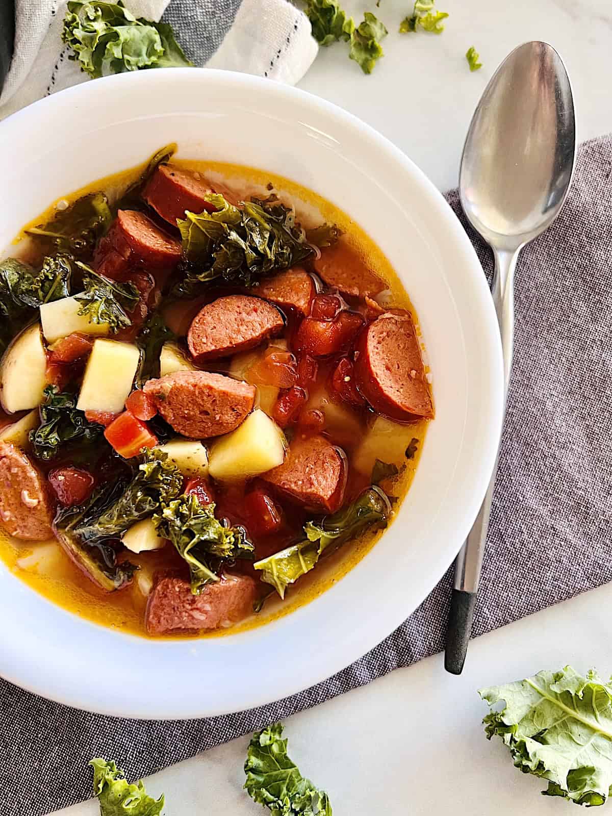 Slow Cooker Sausage Kale Soup Best recipe in a bowl with chunks of potatoes & no cream.