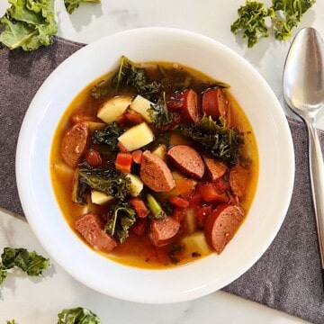 Bowl of Slow Cooker sausage kale soup with potatoes.