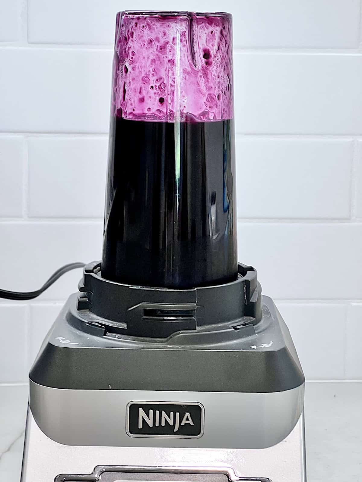 Blender with sugar and blueberries to puree.