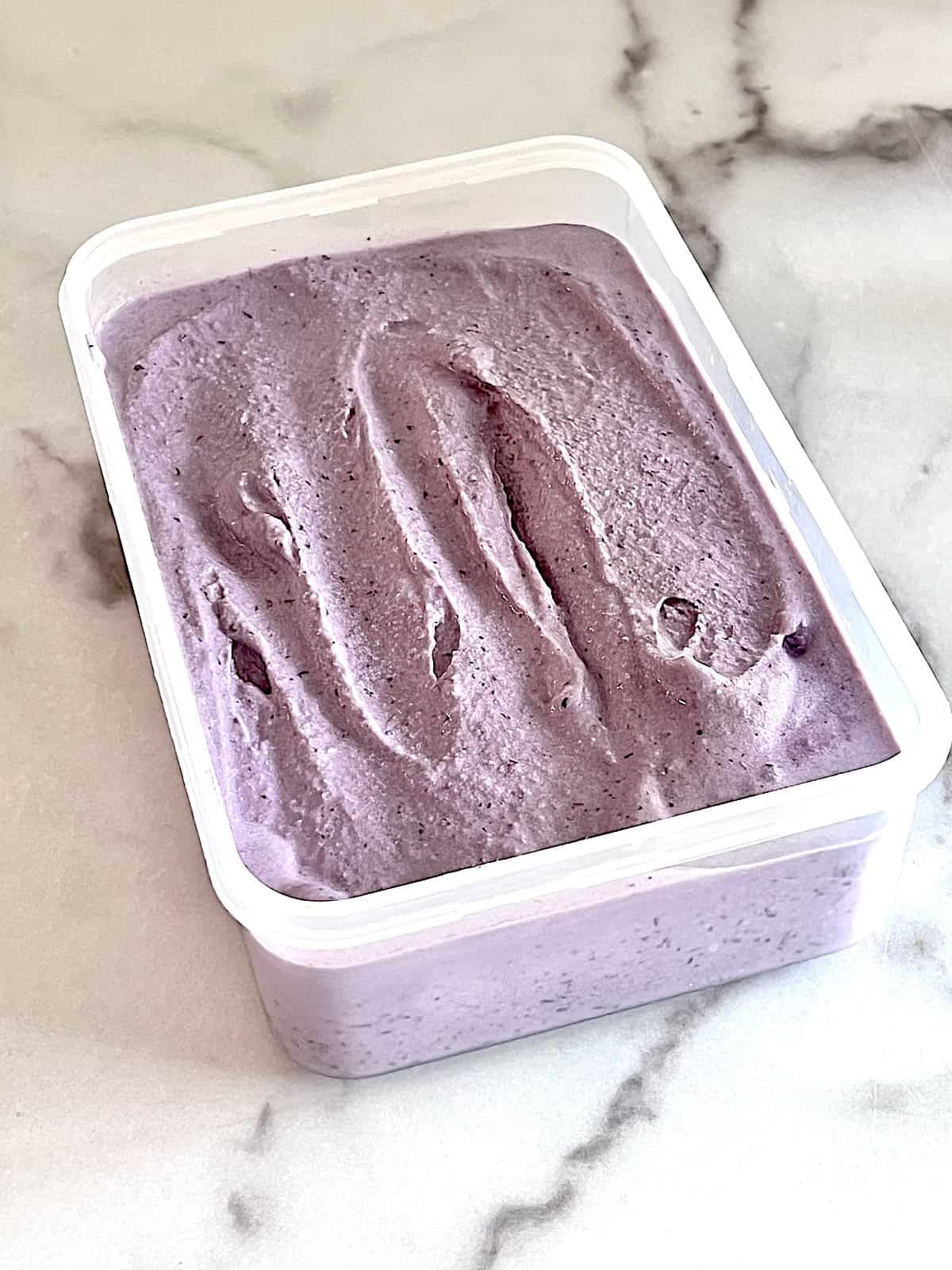 Container with fresh churned ice cream before freezing.