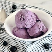 Bowl with scoops of fresh blueberry ice cream made in a cuisinart ice cream maker.