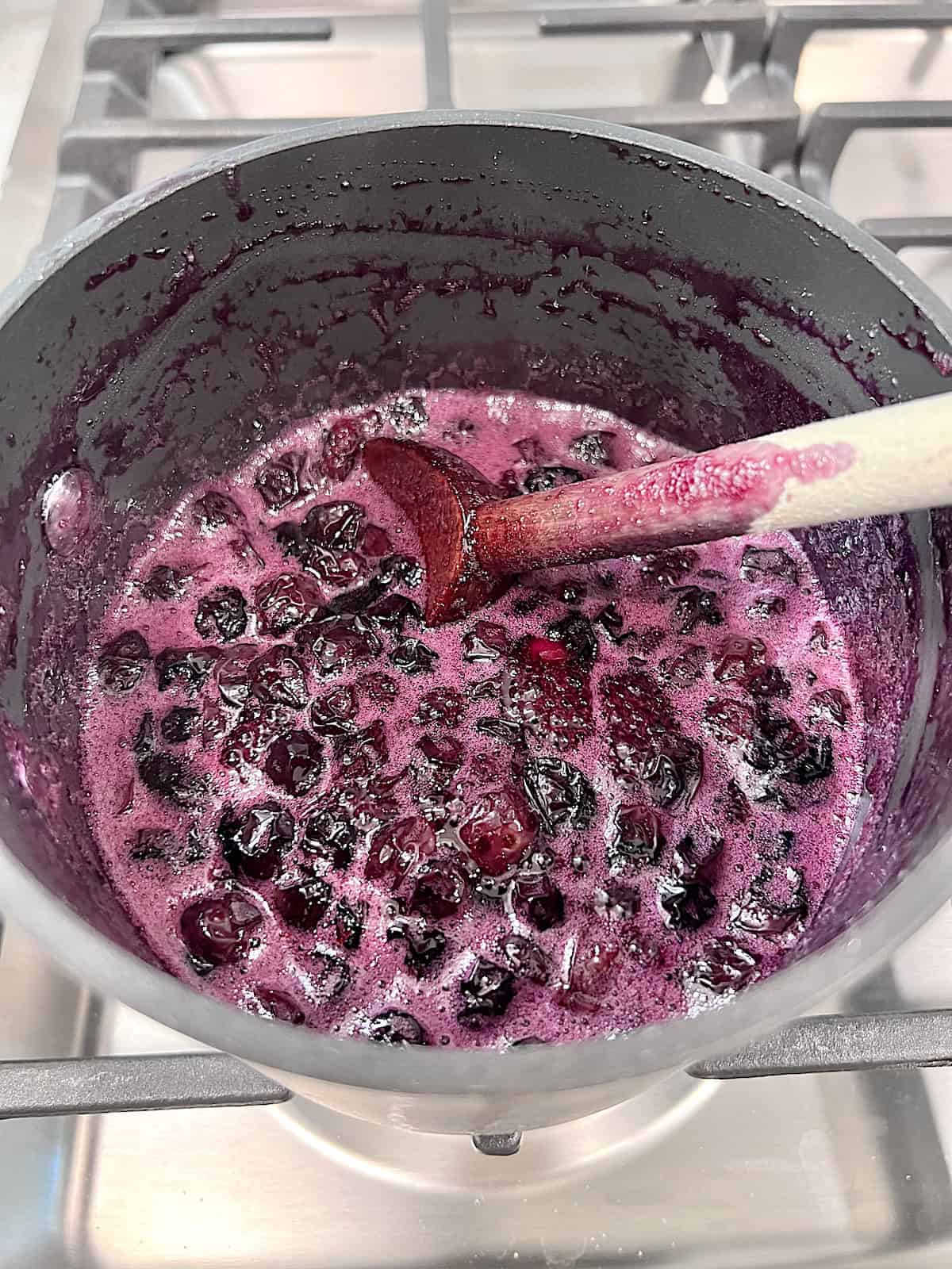 Simmering berry mix in a pot on the stove.