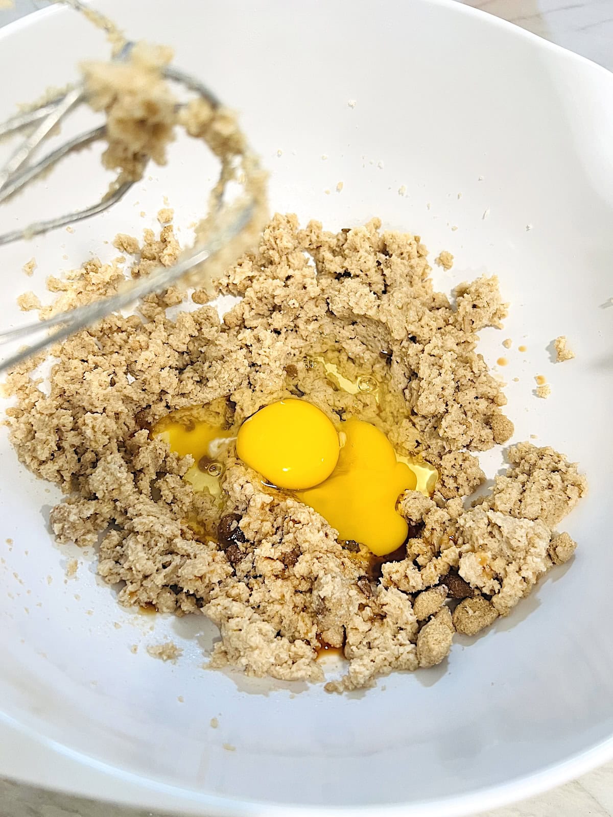 Adding eggs and vanilla to butter and sugar.