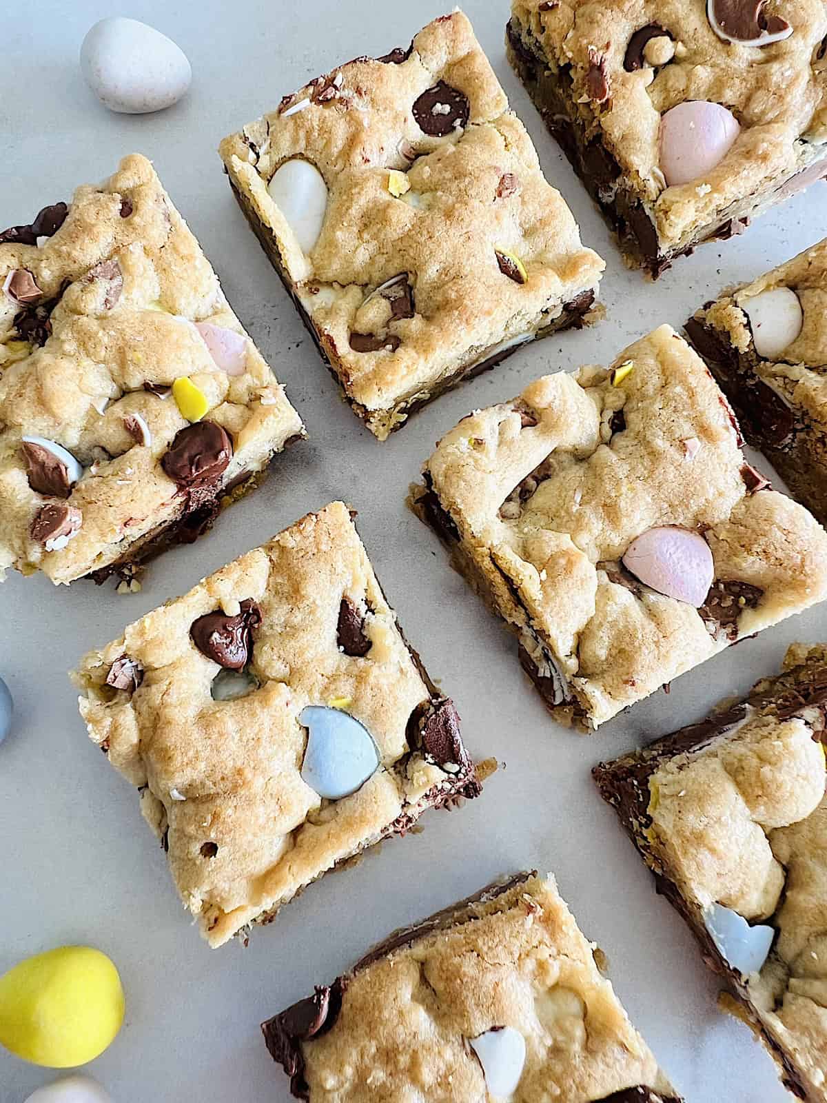 Cadbury Mini Egg Cookie Bars Cut in squares with candies.