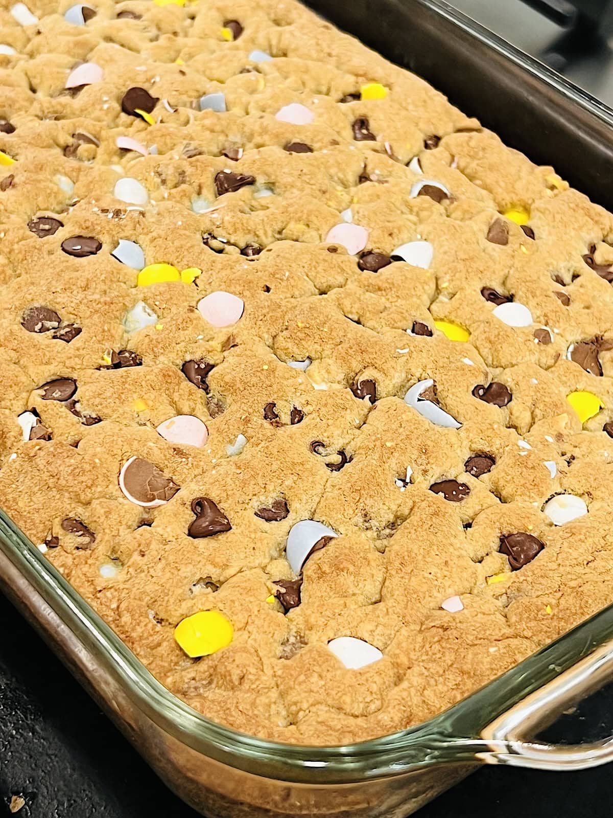 Cadbury Mini Egg Cookie Bars Golden brown and baked resting in the pan before cutting.