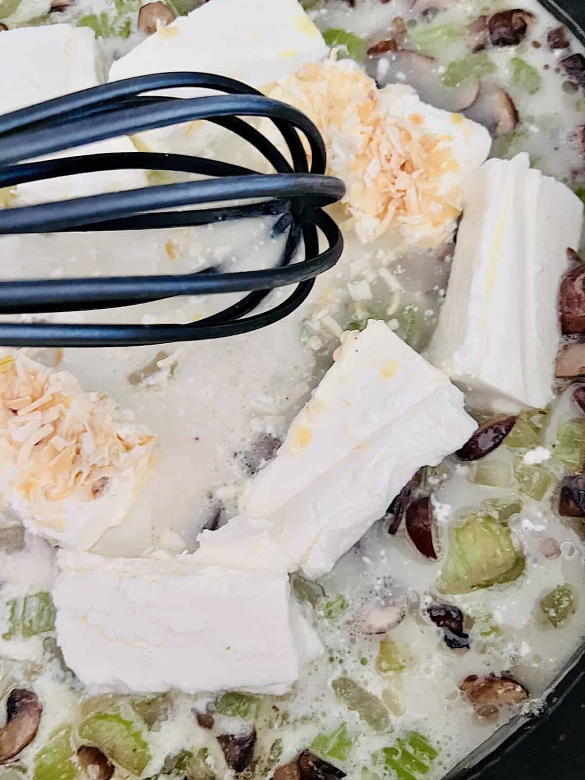 Whisking in cream and cream cheese into pot pie filling.