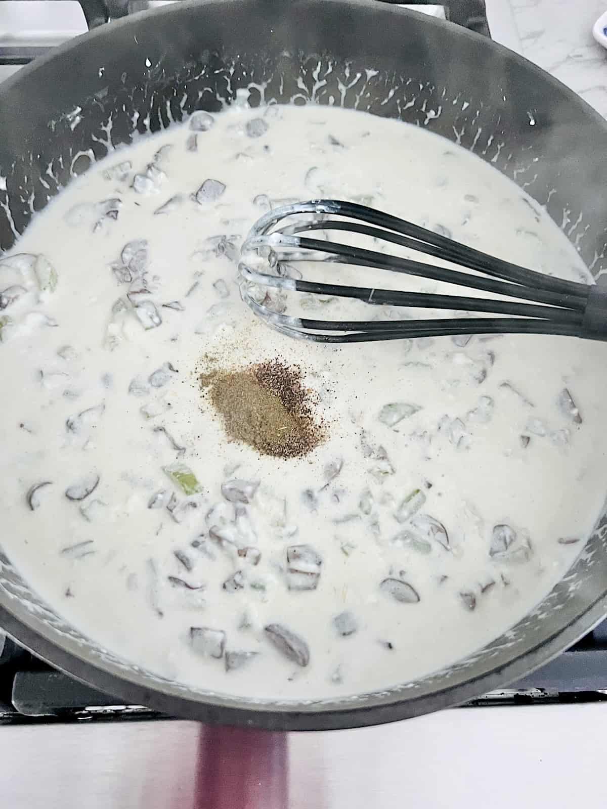 Adding spices to pot pie filling.