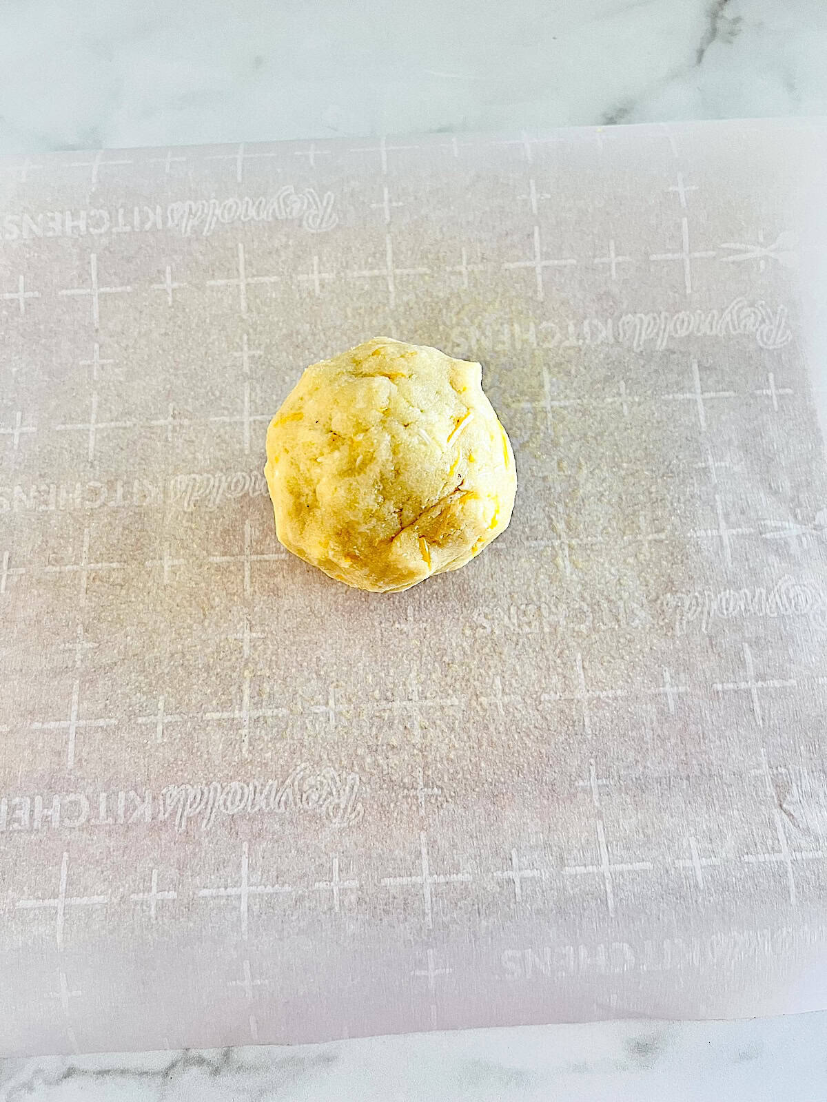 Ball of almond flour pie crust dough on parchment.