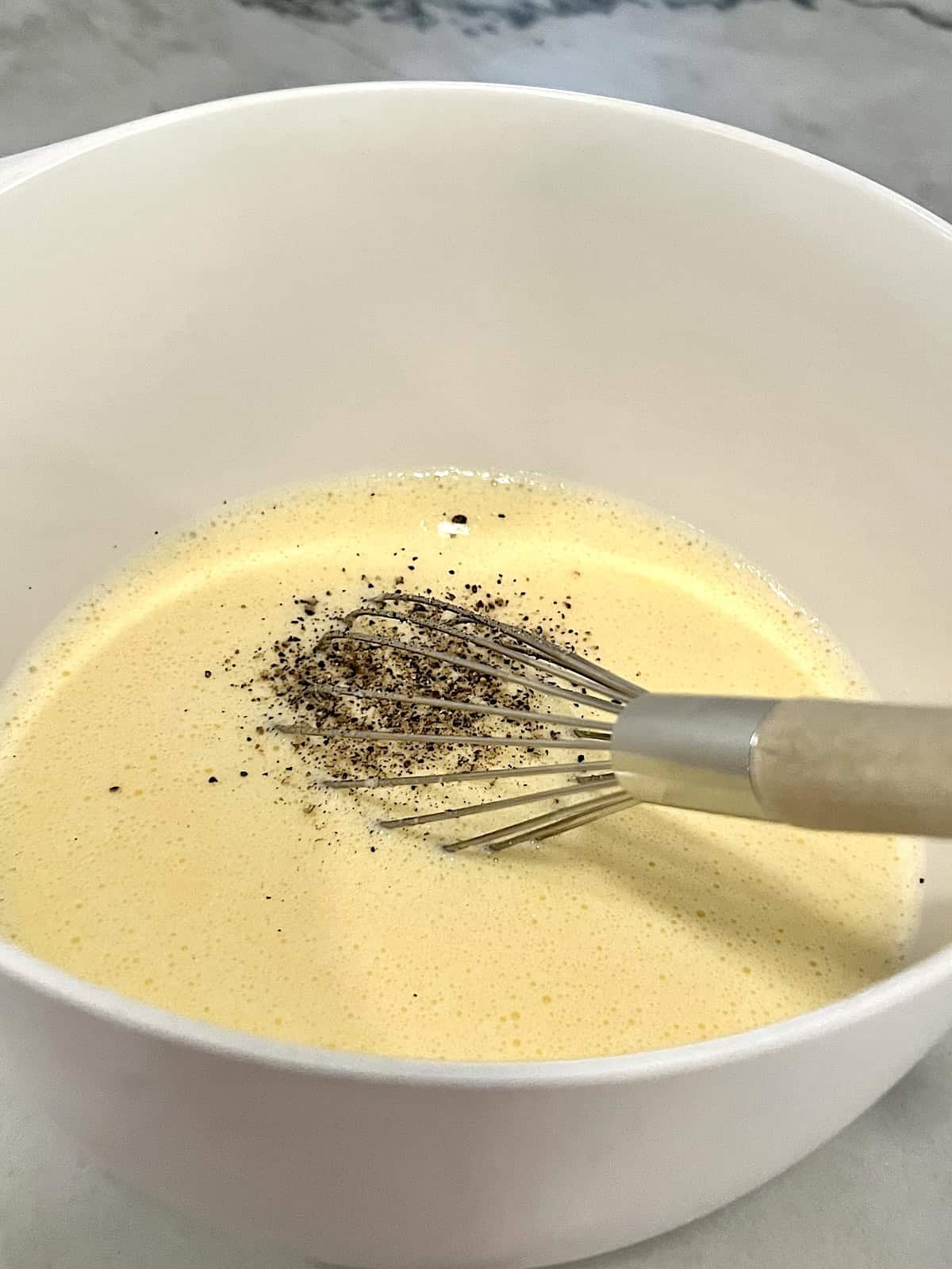 Whisking egg custard in bowl.