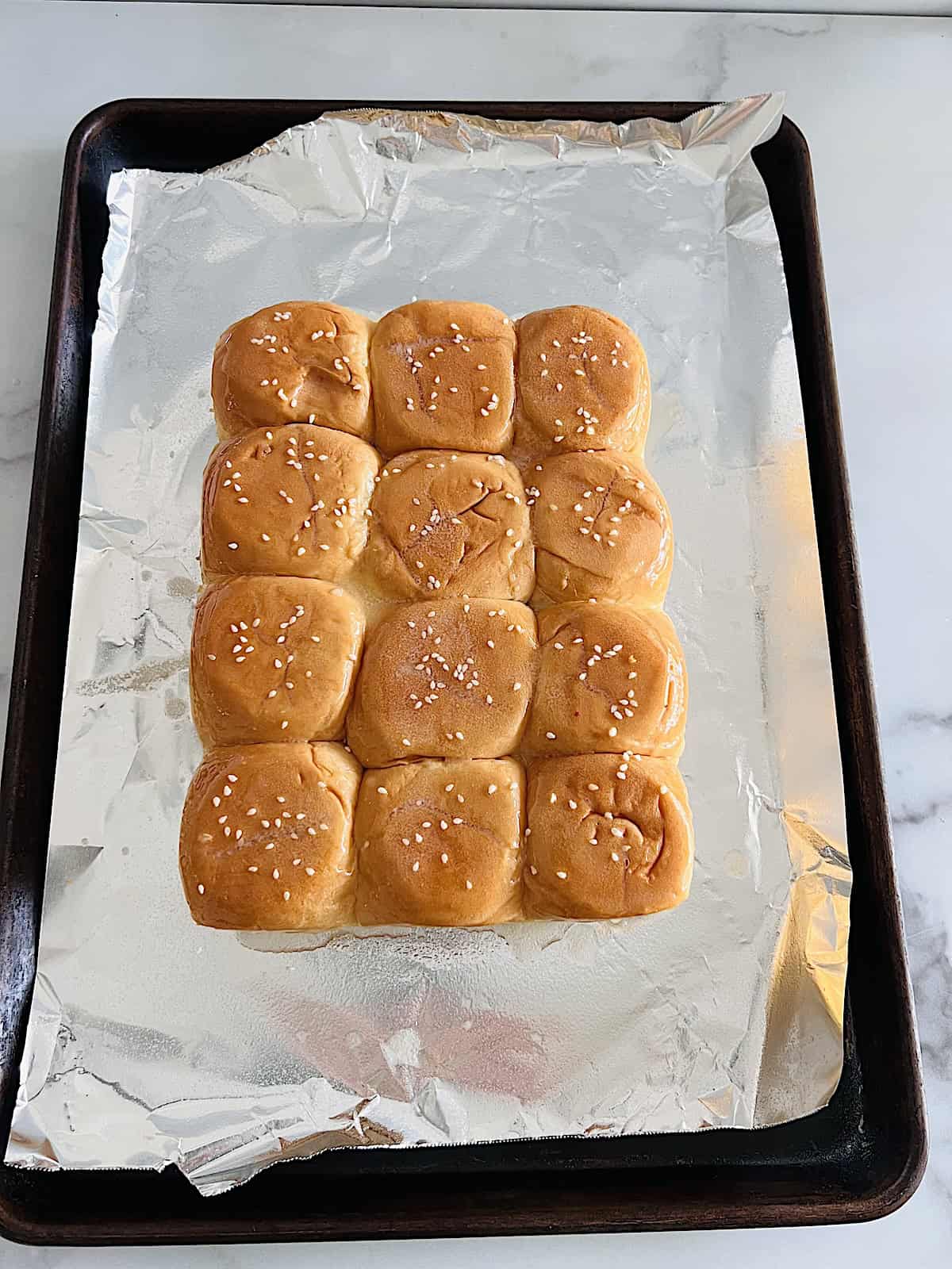 Basted on top with melted butter and sesame seeds.
