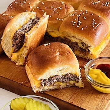 Cheeseburger Sliders on Hawaiian Rolls with ground beef patty and American Cheese slices baked & melty.
