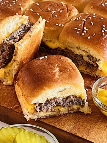 Cheeseburger Sliders on Hawaiian Rolls with ground beef patty and American Cheese slices baked & melty.