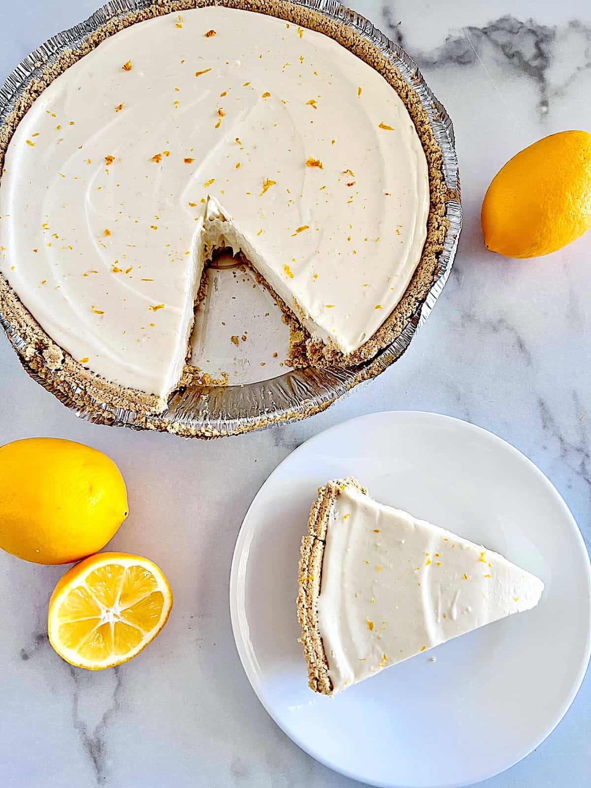 No-Bake Lemon Cheesecake Pie Slice removed from whole pie and plated.