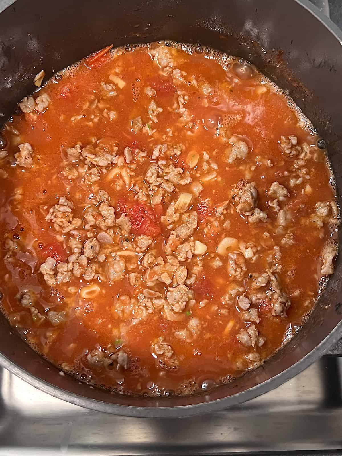 Rigatoni and Meat Sauce Pot with garlic and meat simmering.