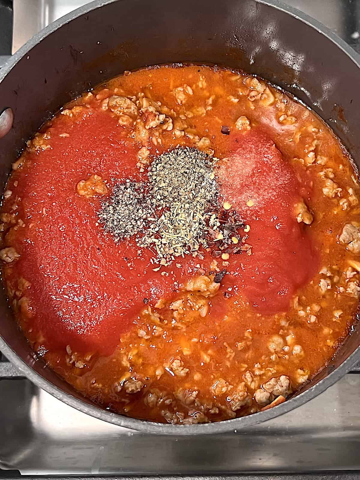 Tomato meat sauce in a pot topped with spices.