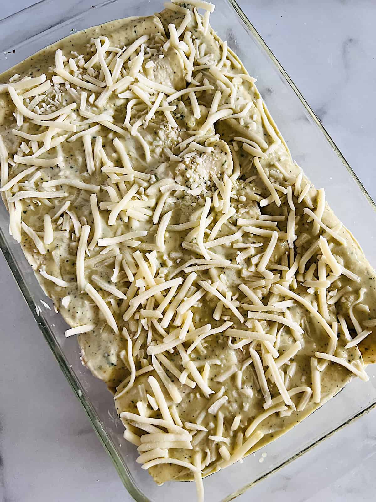 Before baking assembled enchilada suizas with sauce and cheese.