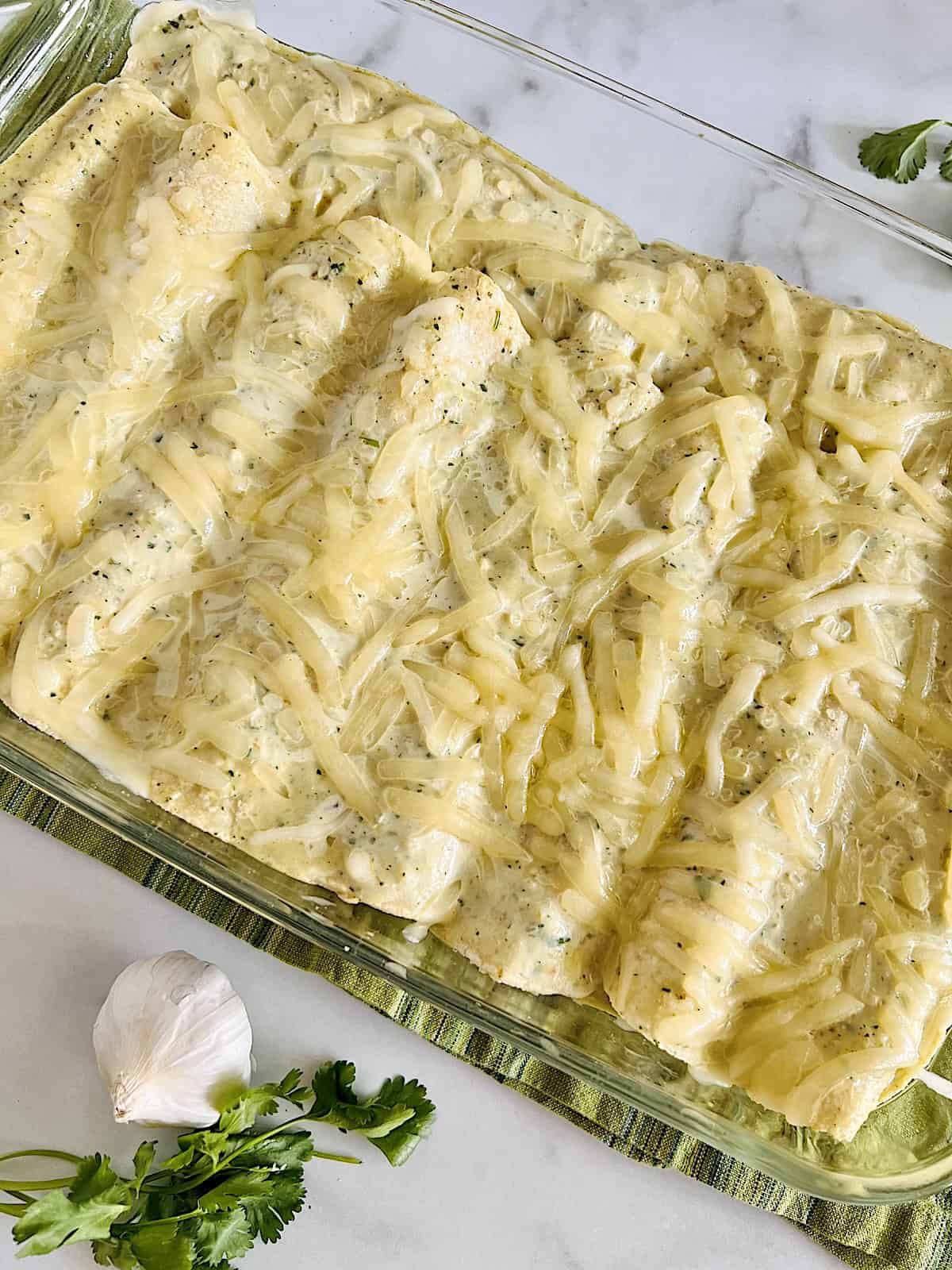 Enchiladas Suizas Best recipe with shredded chicken, cheese, & sour cream green sauce.