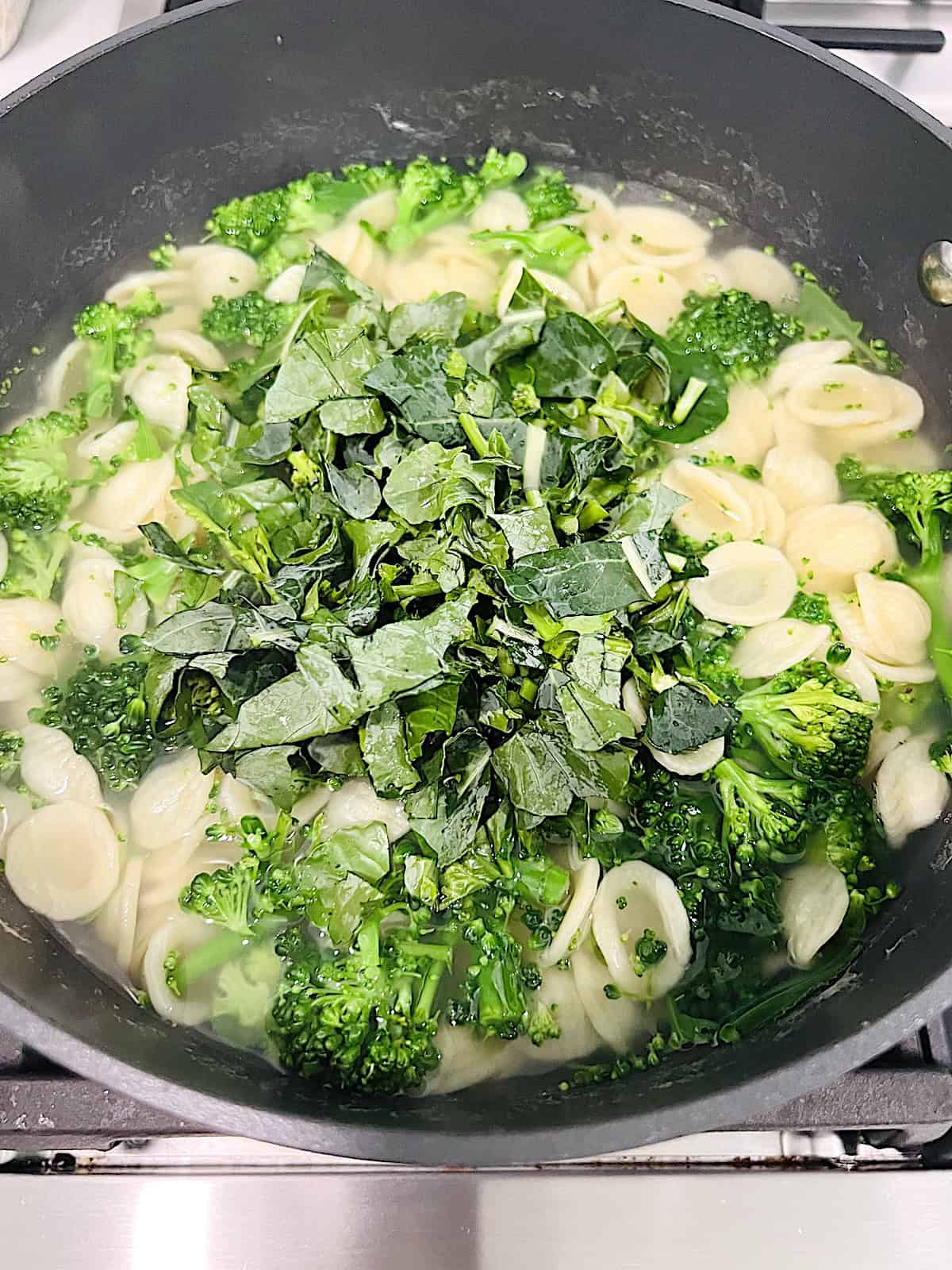 Orecchiette with Sausage and Broccoli Rabe Adding greens to cooked pasta.