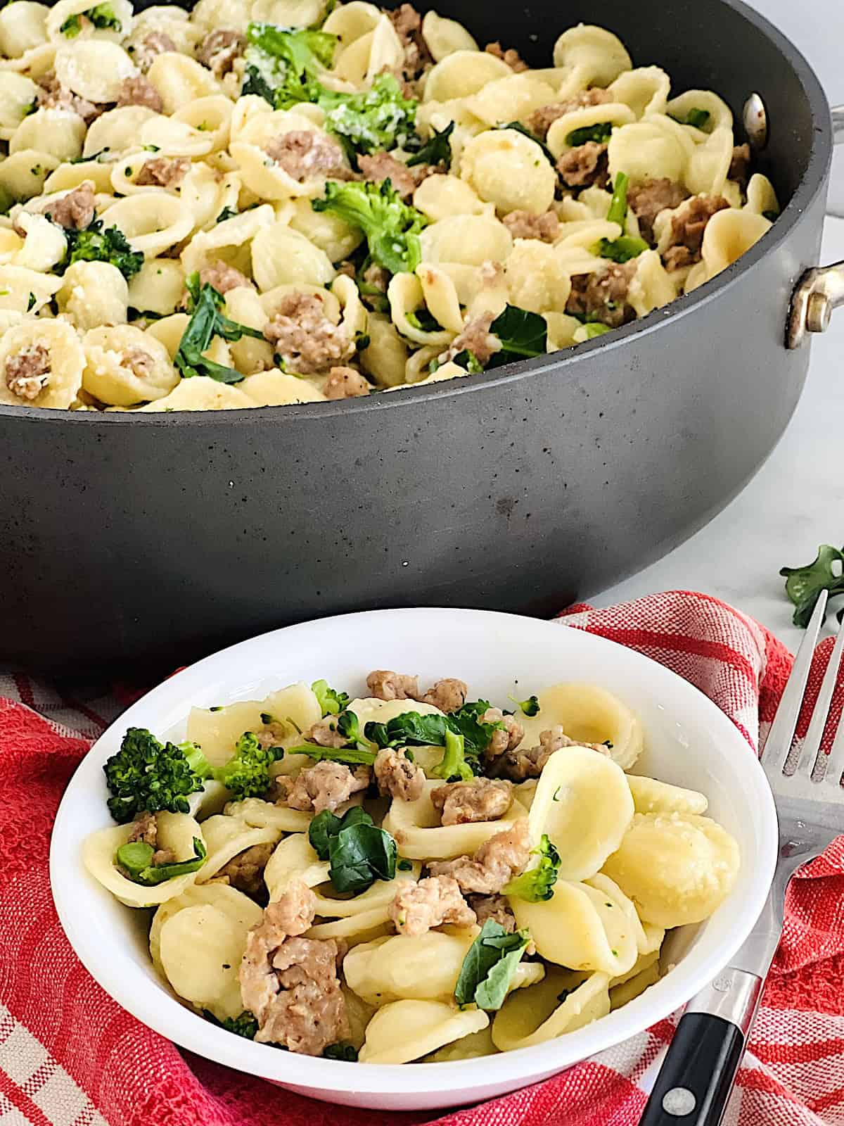 Orecchiette with Sausage and Broccoli Rabe Serving portrait with large pot and bowl with fork.